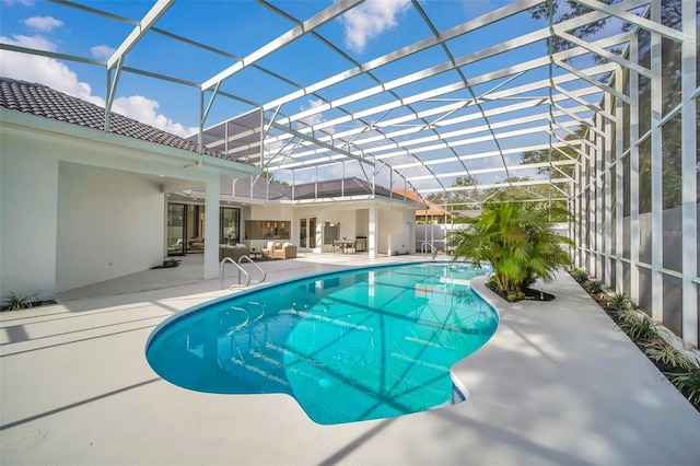 view of swimming pool with glass enclosure and a patio area