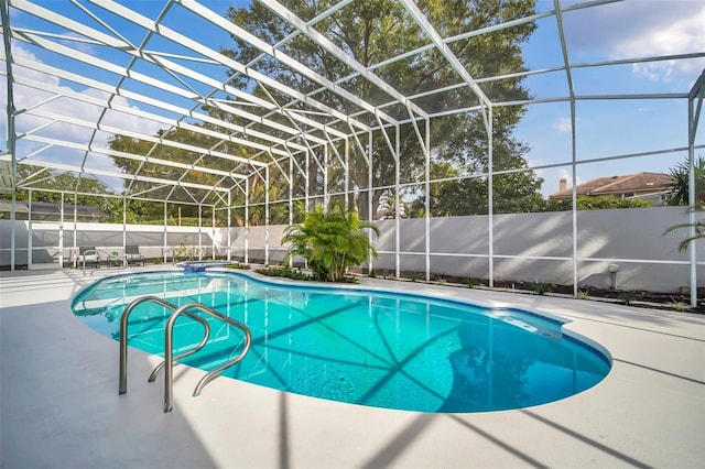 view of pool with glass enclosure and a patio area