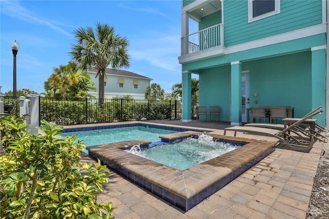 view of swimming pool featuring a patio and an in ground hot tub