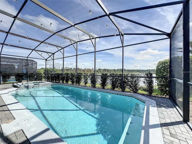 view of swimming pool featuring a lanai, a patio area, and an in ground hot tub