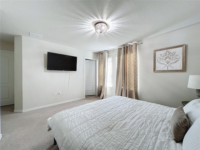 carpeted bedroom with a textured ceiling and a closet