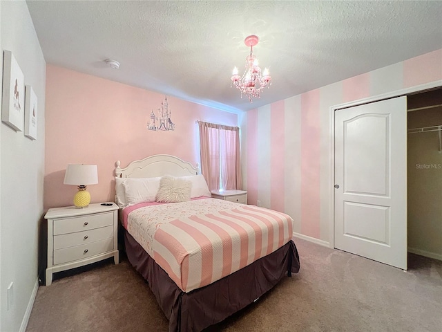 bedroom with a chandelier, carpet, and a textured ceiling