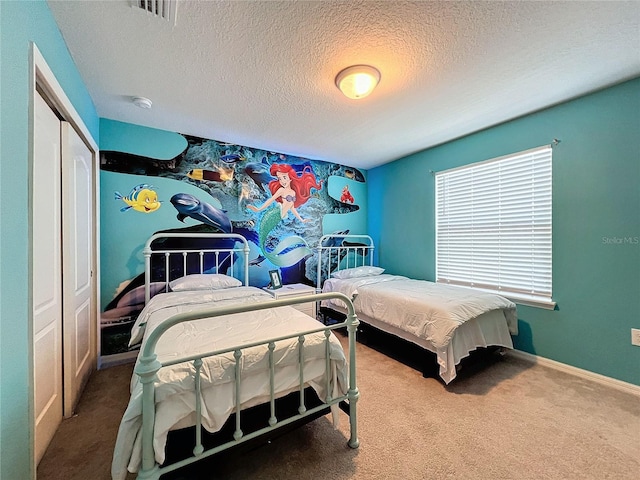 carpeted bedroom with a textured ceiling and a closet