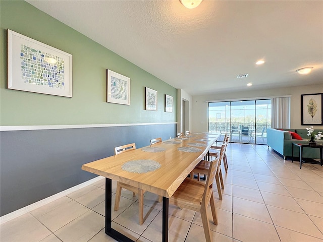 tiled dining space with a textured ceiling