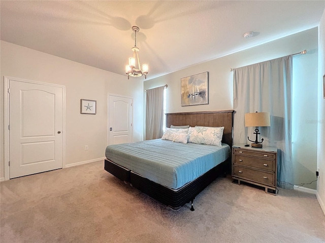 bedroom featuring light colored carpet and a notable chandelier