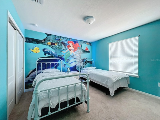 carpeted bedroom featuring a closet and a textured ceiling