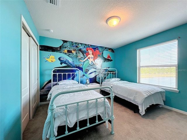 carpeted bedroom with a closet and a textured ceiling