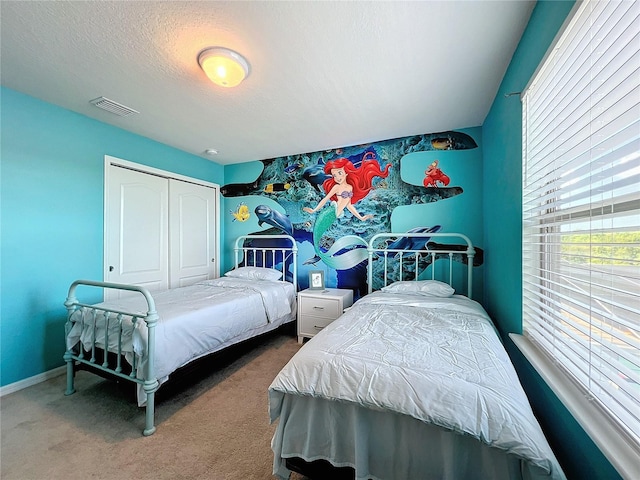 bedroom with carpet, a textured ceiling, and a closet