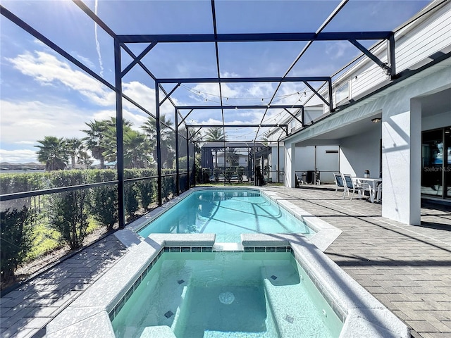 view of pool with a lanai, a patio, and an in ground hot tub