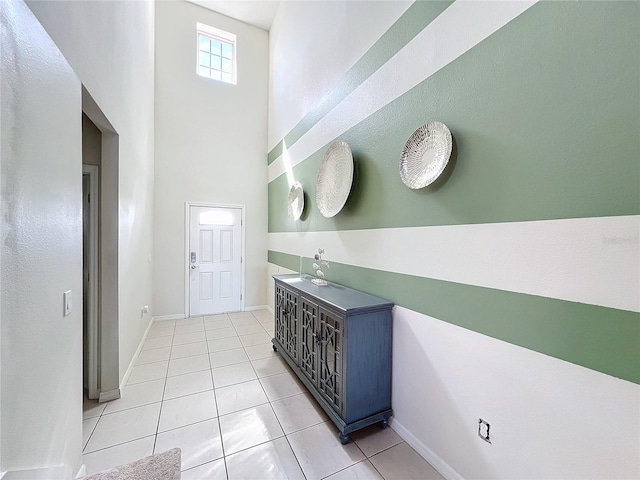 entryway featuring light tile patterned floors and a high ceiling