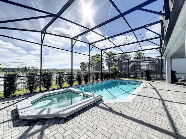 view of swimming pool featuring an in ground hot tub, a patio, and glass enclosure