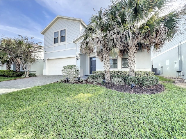 view of front of property featuring cooling unit, a garage, and a front lawn