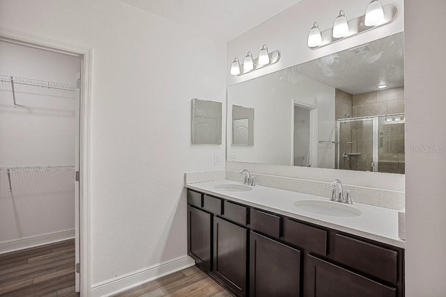 bathroom featuring vanity, hardwood / wood-style flooring, and a shower with door