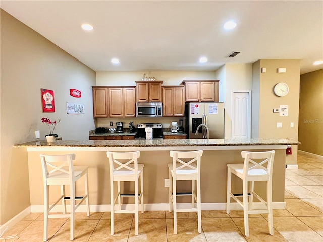 kitchen featuring appliances with stainless steel finishes, recessed lighting, visible vents, and a kitchen breakfast bar