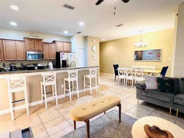 kitchen featuring light tile patterned floors, recessed lighting, visible vents, a kitchen breakfast bar, and appliances with stainless steel finishes