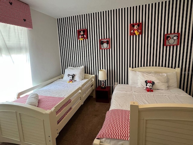 bedroom with dark carpet and wallpapered walls