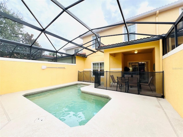 outdoor pool with glass enclosure and a patio area
