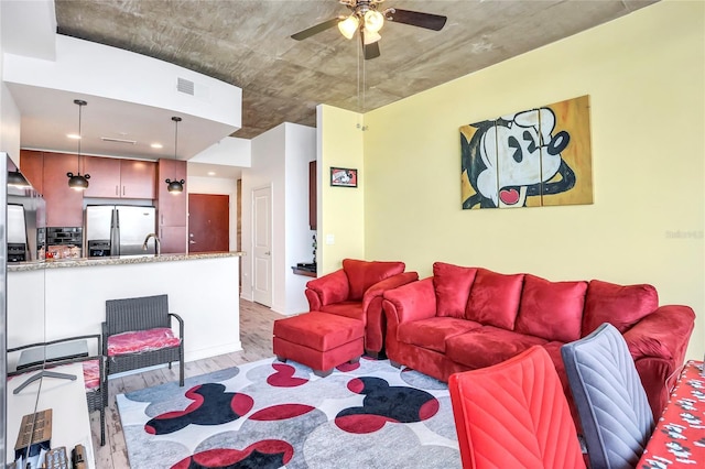 living room with ceiling fan and light hardwood / wood-style floors