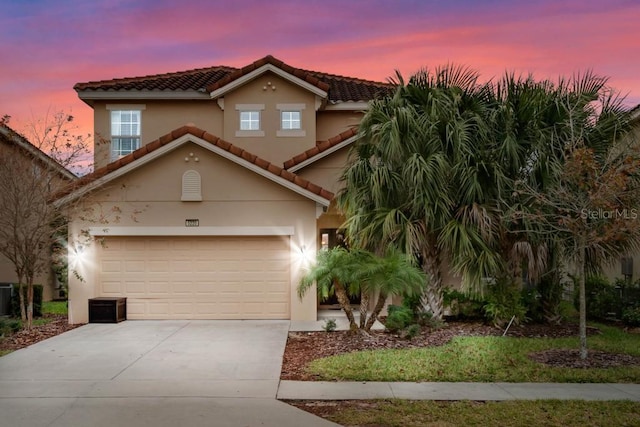 5220 Oakbourne Ave, Davenport, FL 33837 - view of front of house with driveway, a tiled roof, stucco siding, and an attached garage