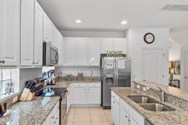 kitchen with sink, light stone counters, stainless steel appliances, and light tile patterned floors