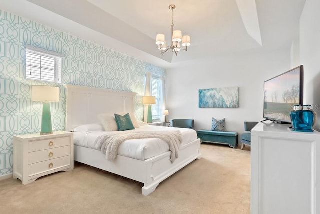 bedroom featuring light carpet, a notable chandelier, and a tray ceiling