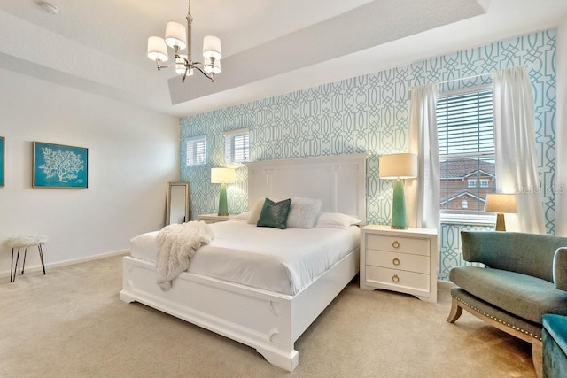 bedroom with light carpet, a raised ceiling, multiple windows, and an inviting chandelier