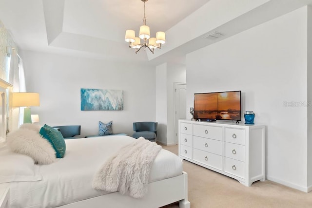 bedroom with an inviting chandelier, a tray ceiling, and light colored carpet