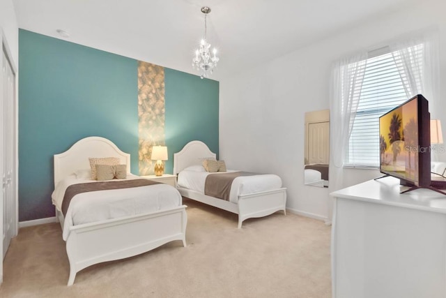 bedroom featuring an inviting chandelier and light carpet