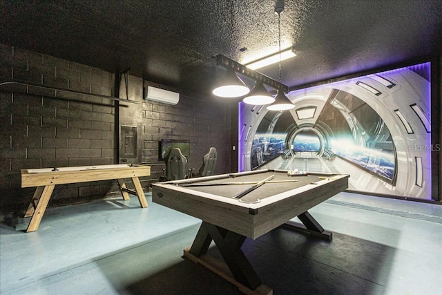 game room with concrete floors, pool table, a wall mounted air conditioner, and a textured ceiling