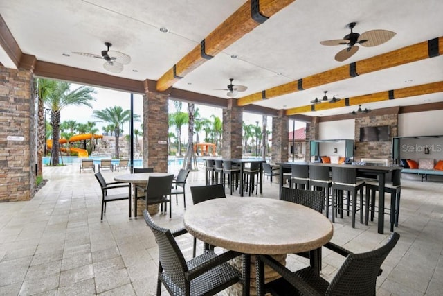 interior space featuring ceiling fan and a bar