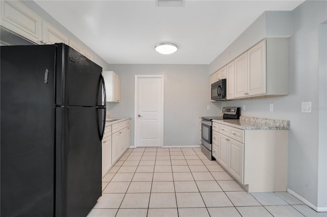 kitchen with light tile patterned flooring, white cabinets, and black appliances