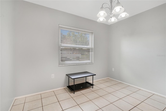 unfurnished room with light tile patterned floors and a chandelier