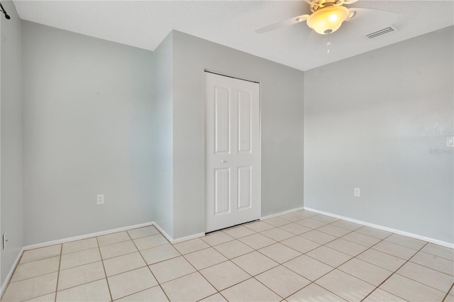 tiled spare room with ceiling fan