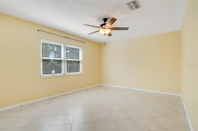 empty room with light tile patterned floors, a textured ceiling, and ceiling fan