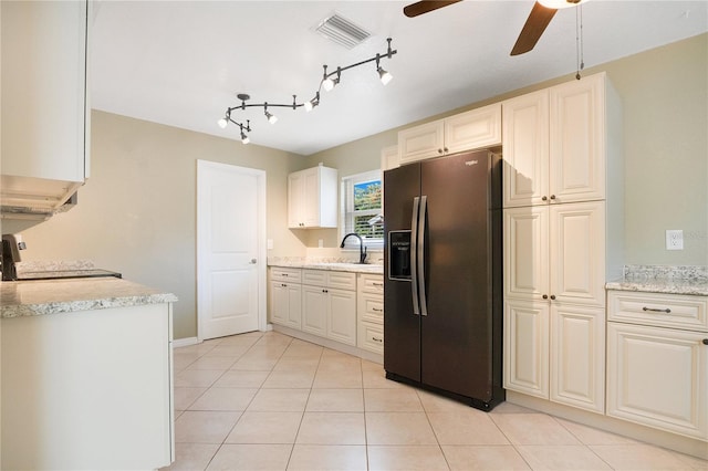 kitchen with stove, sink, ceiling fan, light tile patterned floors, and black fridge with ice dispenser