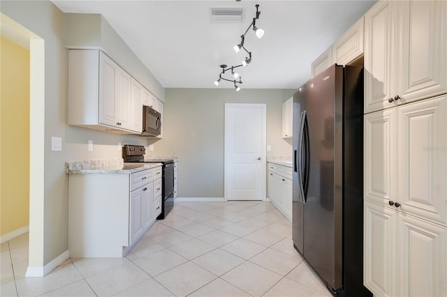 kitchen featuring black appliances, light tile patterned flooring, white cabinets, and light stone countertops