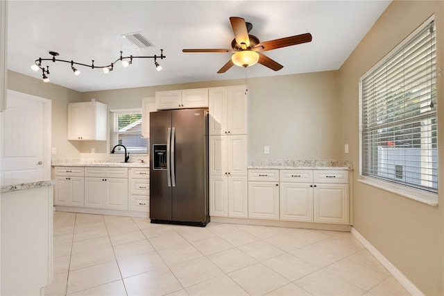 kitchen featuring white cabinetry, stainless steel fridge with ice dispenser, and light stone counters