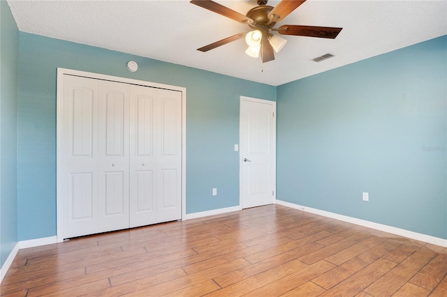 unfurnished bedroom with light wood-type flooring, a closet, and ceiling fan