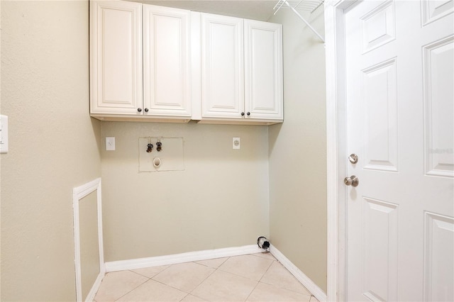 washroom featuring cabinets, light tile patterned floors, and hookup for a washing machine