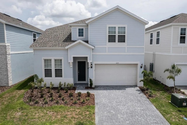 4189 Lana Ave, Davenport, FL 33897 - view of front of home with decorative driveway, roof with shingles, an attached garage, and stucco siding