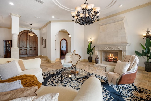 living room with a fireplace, a chandelier, ornate columns, and crown molding