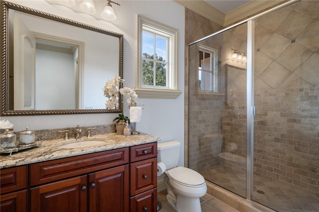 bathroom with vanity, toilet, a shower with shower door, and crown molding