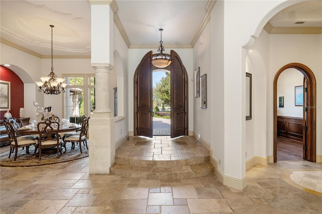 foyer with crown molding, a high ceiling, and a chandelier