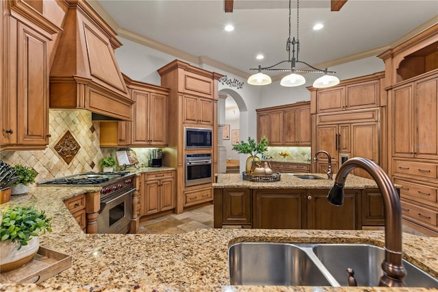 kitchen with stainless steel appliances, custom exhaust hood, hanging light fixtures, and sink