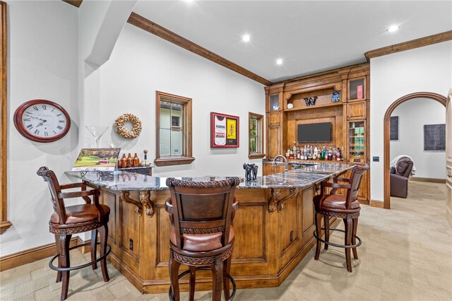 bar featuring crown molding, light carpet, and stone counters