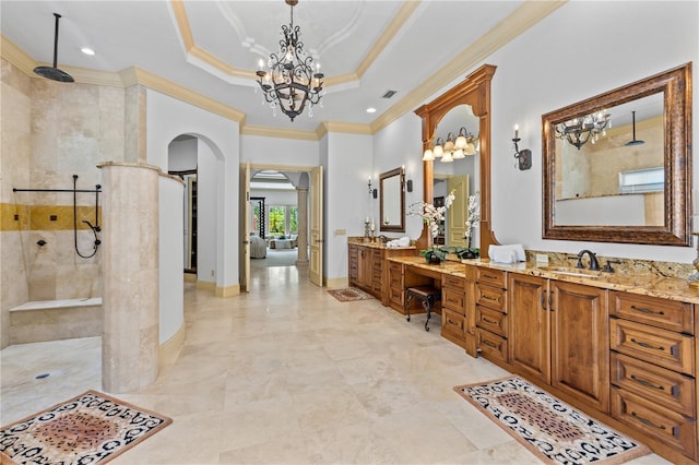 bathroom featuring ornamental molding, a tile shower, vanity, a tray ceiling, and a chandelier