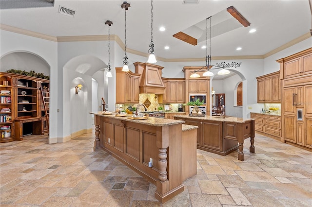 kitchen featuring a kitchen bar, kitchen peninsula, light stone countertops, and decorative light fixtures