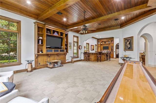 living room with ceiling fan, a wealth of natural light, and wood ceiling