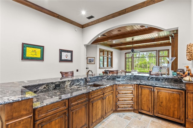 kitchen featuring crown molding, sink, wooden ceiling, dark stone countertops, and beamed ceiling