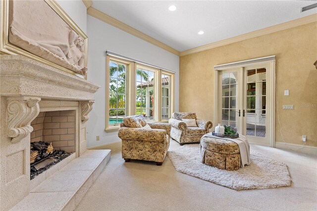 living area featuring a tile fireplace, french doors, crown molding, and carpet